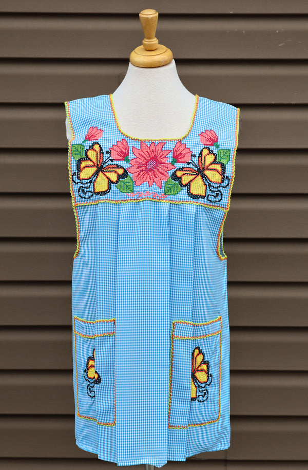 Baby blue gingham Mexican apron with colorful cross-stitch embroidery and front pockets