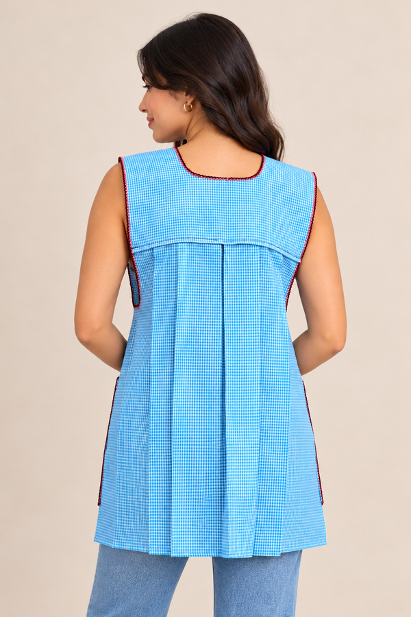 Back view of handmade baby blue gingham Mexican apron showing its pleated design and sleeveless construction.