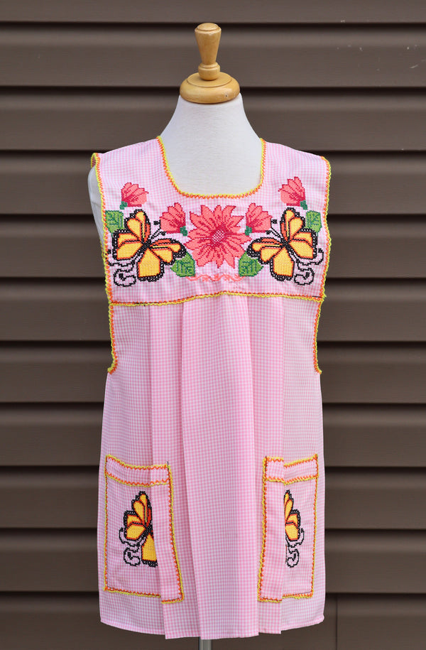 Baby pink gingham Mexican apron with colorful cross-stitch embroidery and front pockets