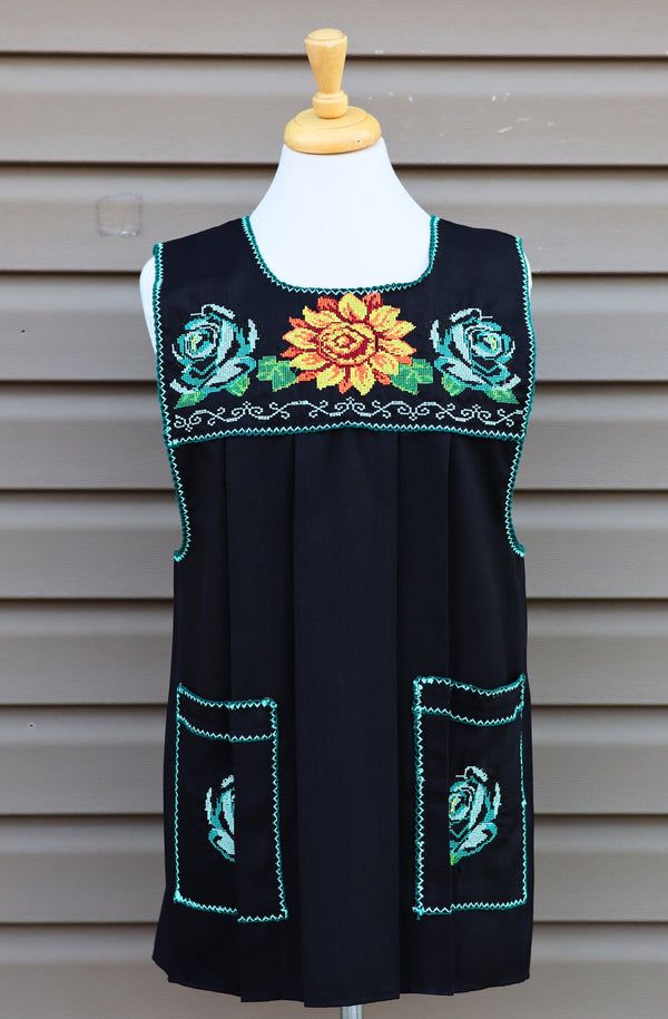 Black Mexican apron with colorful cross-stitch embroidery and front pockets