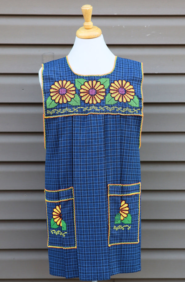 Blue plaid Mexican apron with colorful cross-stitch embroidery and front pockets