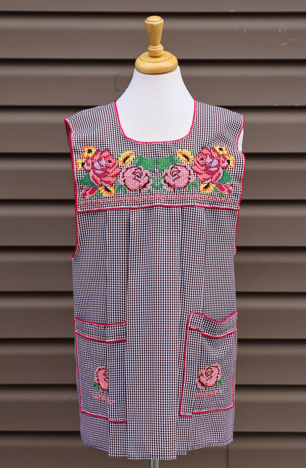 Brown gingham Mexican apron with colorful cross-stitch embroidery and front pockets