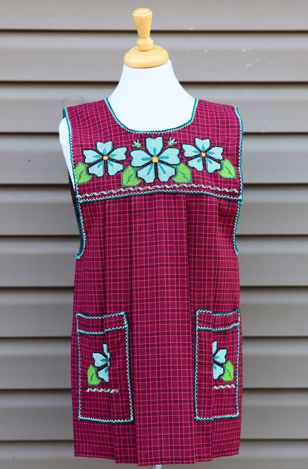 Burgundy plaid Mexican apron with colorful cross-stitch embroidery and front pockets