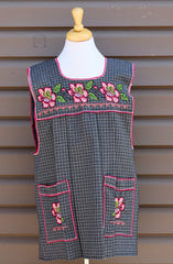 Gray plaid Mexican apron with colorful cross-stitch embroidery and front pockets