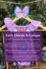 A lavender baby bodysuit with colorful floral embroidery, hanging on a wooden hanger with a matching white bow headband. The background features lush green houseplant leaves, and a large purple text box overlays the lower half with information about customization.