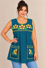 Full-length front view of a handmade Mexican apron featuring sunflower embroidery, teal blue plaid fabric, and two embroidered front pockets.